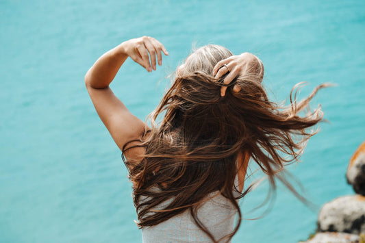 back-view-photo-of-woman-in-white-sleeveless-shirt-running-her-fingers-through-her-hair