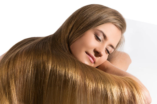 blond, long-haired female has her eyes closed with her head on her arms  